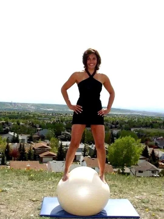 Nina Midtgaard at 50, standing balanced on an exercise ball outdoors.
